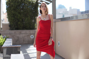 Strappy midi red dress with side rouge and asymmetric bottom.