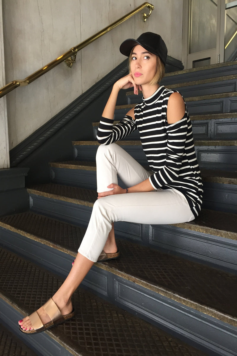 Long sleeve cold shoulder mock neck top in black and white stripes.