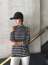 Long sleeve cold shoulder mock neck top in black and white stripes.