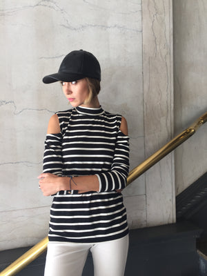 Long sleeve cold shoulder mock neck top in black and white stripes.