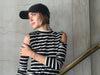 Long sleeve cold shoulder mock neck top in black and white stripes.